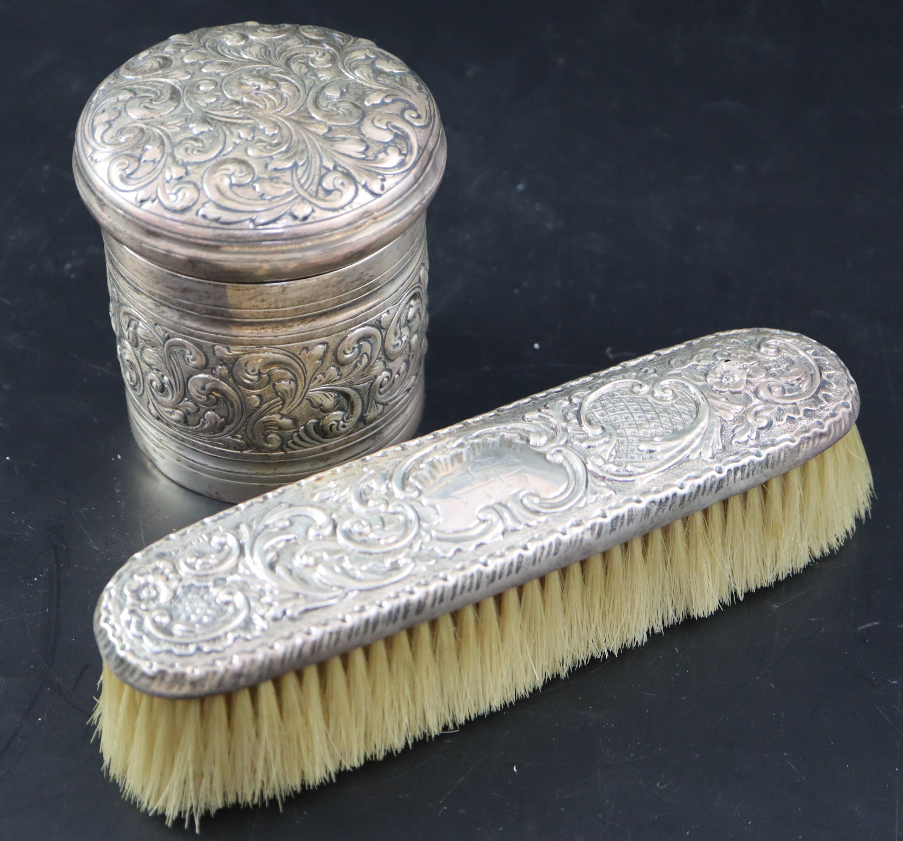 A Victorian embossed silver toilet jar, London, 1887, 93mm, 160 grams and a silver mounted clothes brush.